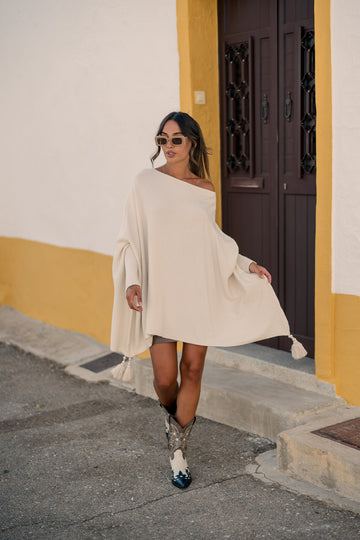 Poncho com pormenor de pompons no remate - bege